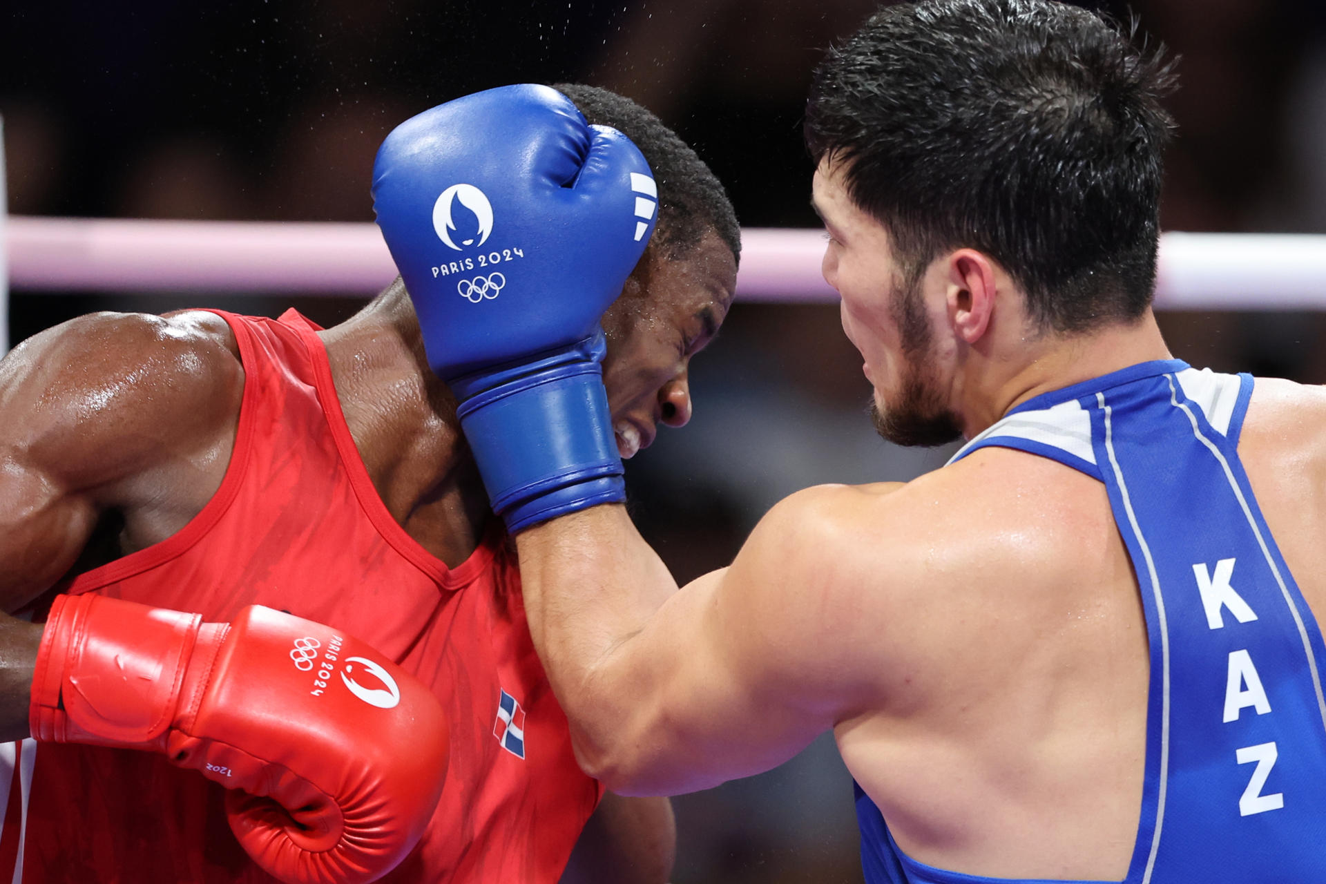 El boxeador kazajo Nurbek Oralbay (azul) se enfrenta al dominicano Javier Cristian Pinales (rojo). EFE/ Miguel Gutiérrez