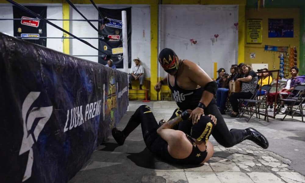 El luchador "Rey Kronos" golpea fuera del cuadrilatero a "discipulo", durante la jornada de lucha libre de Planeta de Campeones en la Ciudad de Guatemala (Guatemala). EFE/David Toro