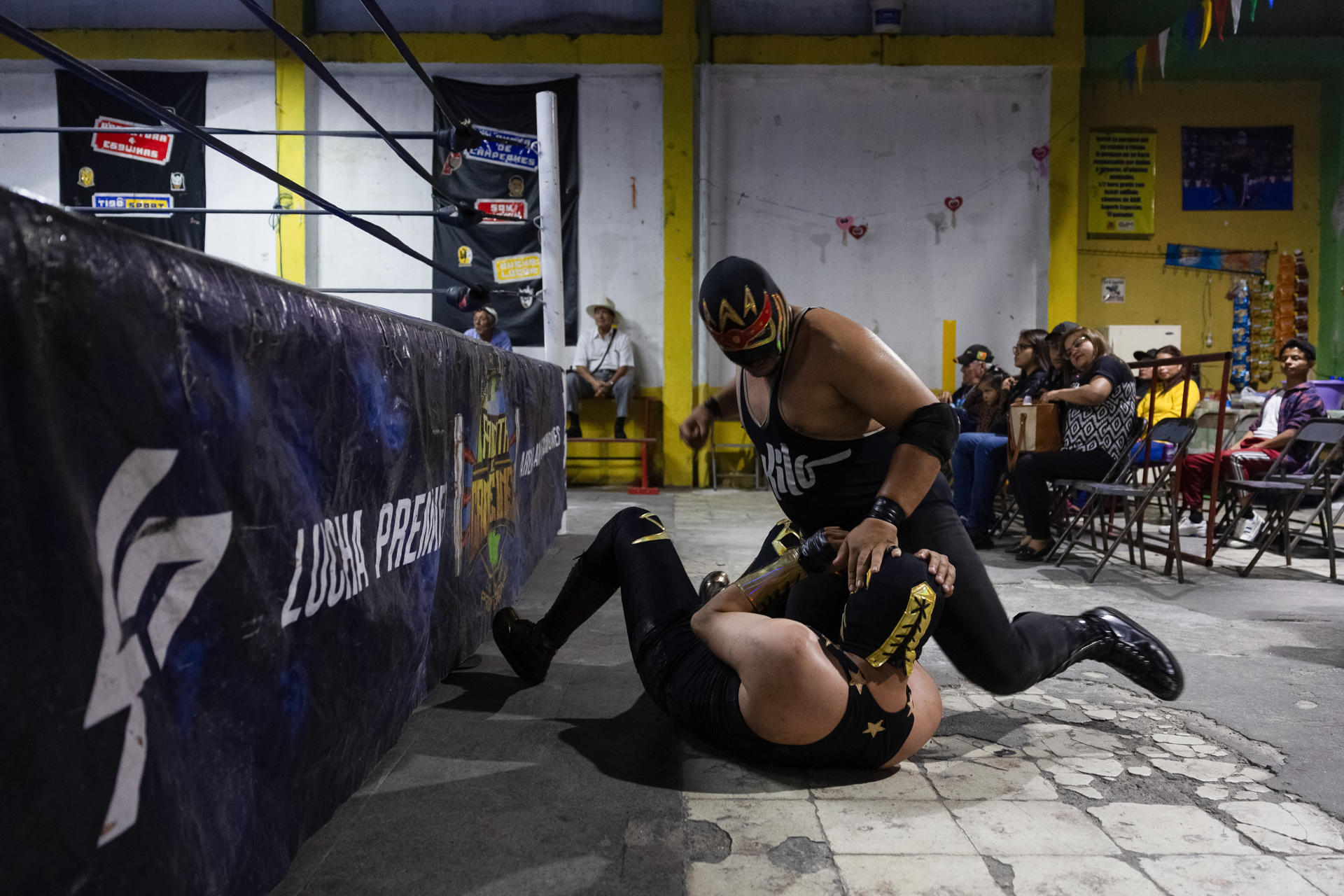 El luchador "Rey Kronos" golpea fuera del cuadrilatero a "discipulo", durante la jornada de lucha libre de Planeta de Campeones en la Ciudad de Guatemala (Guatemala). EFE/David Toro