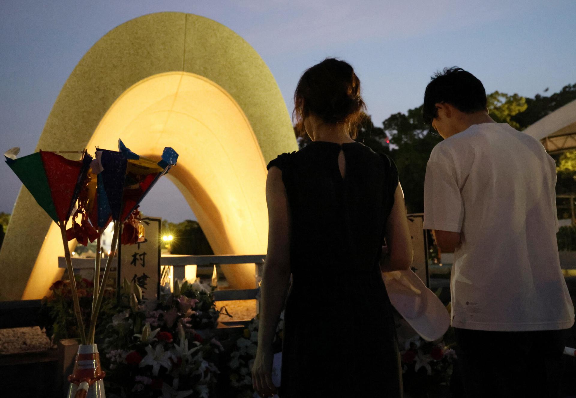 Un grupo de personas ofrece oraciones por las víctimas en el 79 aniversario del bombardeo atómico de Hiroshima frente a un cenotafio temprano en la mañana en el Parque Conmemorativo de la Paz de Hiroshima en Hiroshima, Japón, el 6 de agosto de 2024. EFE/EPA/Jiji press