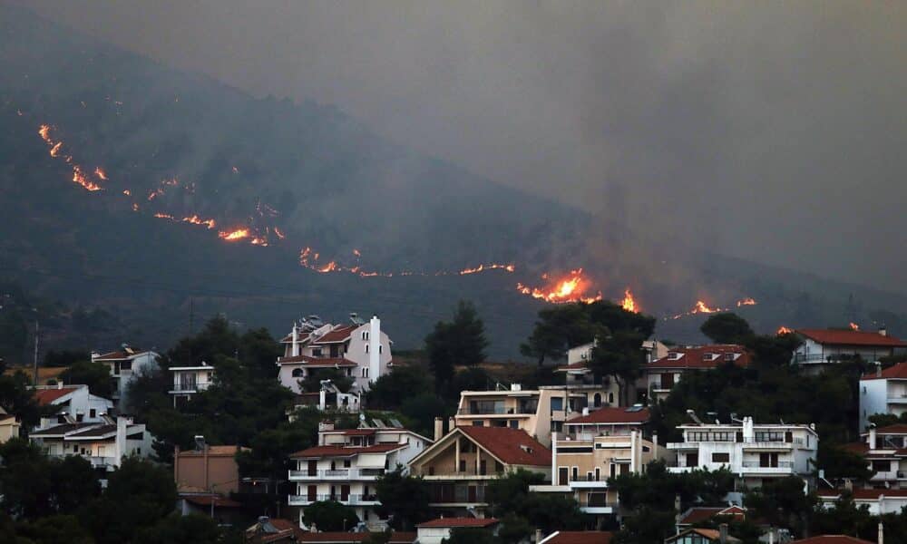 Un incendio se acerca a las casas en el monte Penteli, en el noreste de Grecia, este lunes. EFE/ George Vitsaras