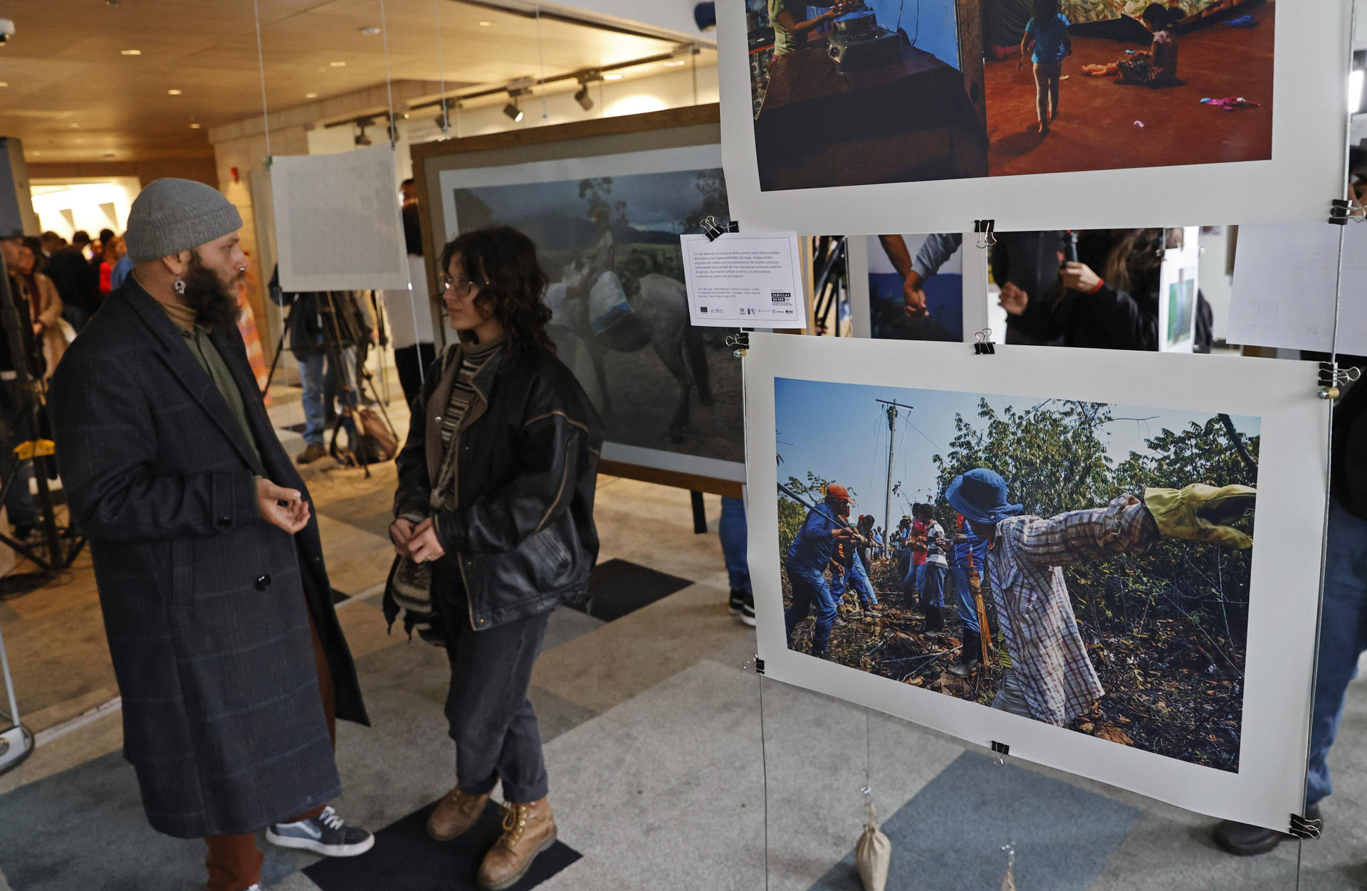 Personas asisnten a la exposición fotográfica hecha por firmantes de paz este lunes, en Bogotá (Colombia). EFE/ Mauricio Dueñas Castañeda