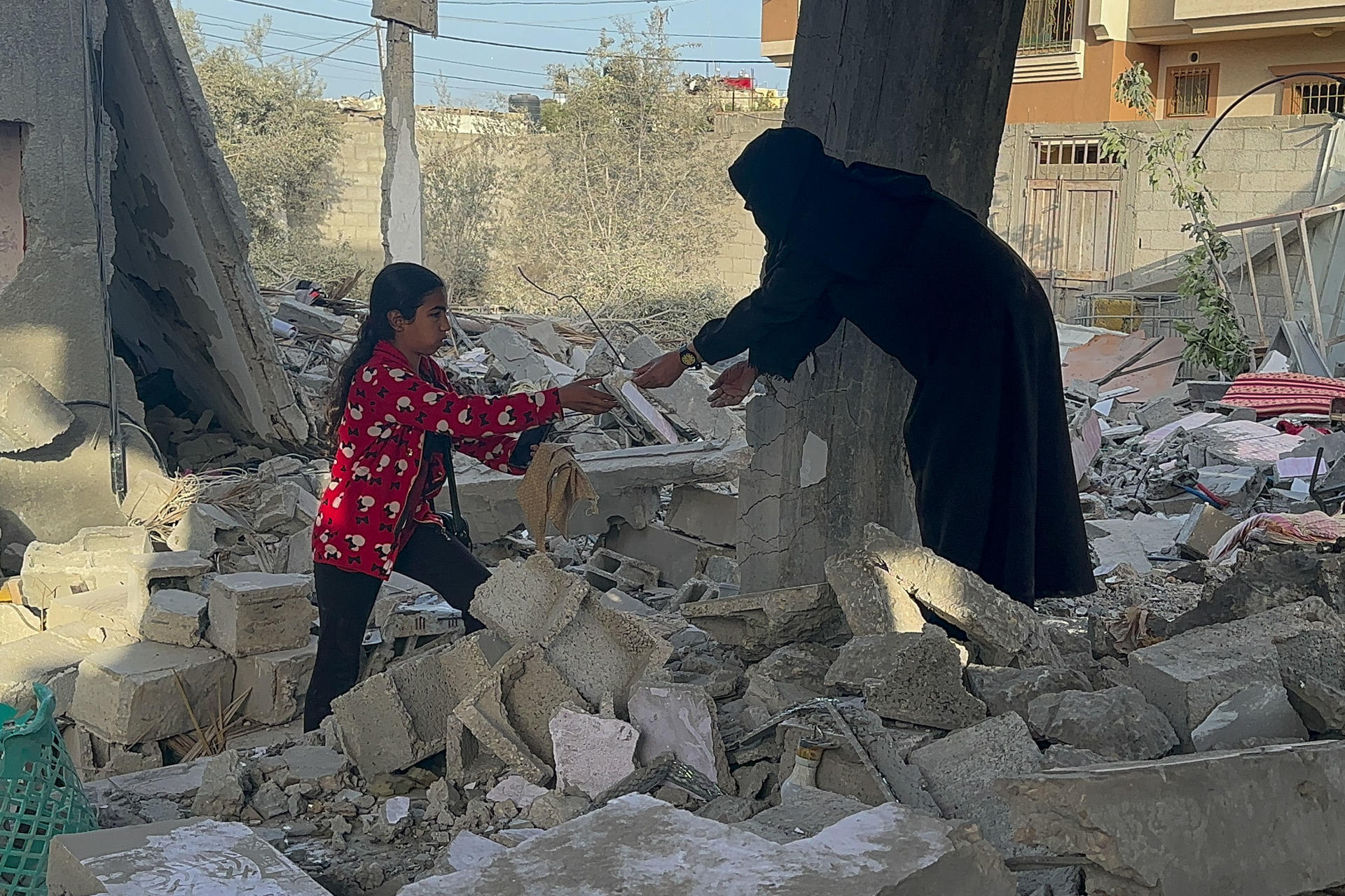 Fotografía de archivo de una mujer y una niña en unos escombros tras el ataque israelí contra una vivienda en la Franja de Gaza. EFE/ EFE