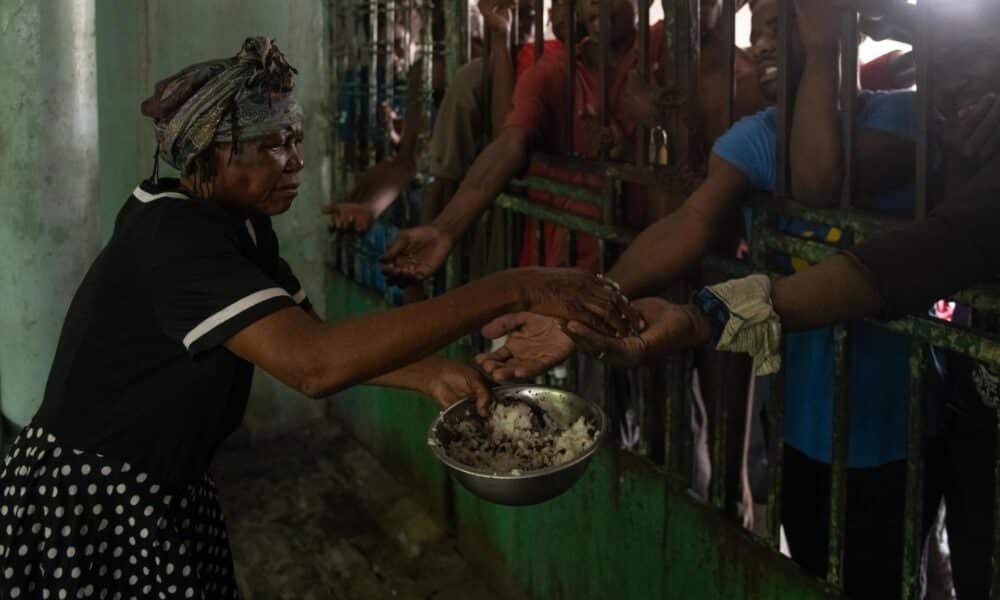 Una mujer da comida a hombres en el centro psiquiátrico Mars & Kline en el centro de Puerto Príncipe (Haití). Fotografía de archivo. EFE/ Johnson Sabin