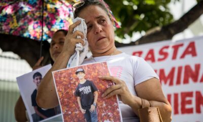 Una mujer llora mientras sostiene una fotografía durante una manifestación y recolección de insumos para familiares "presos políticos" en Caracas (Venezuela). EFE/ Miguel Gutiérrez