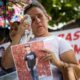 Una mujer llora mientras sostiene una fotografía durante una manifestación y recolección de insumos para familiares "presos políticos" en Caracas (Venezuela). EFE/ Miguel Gutiérrez