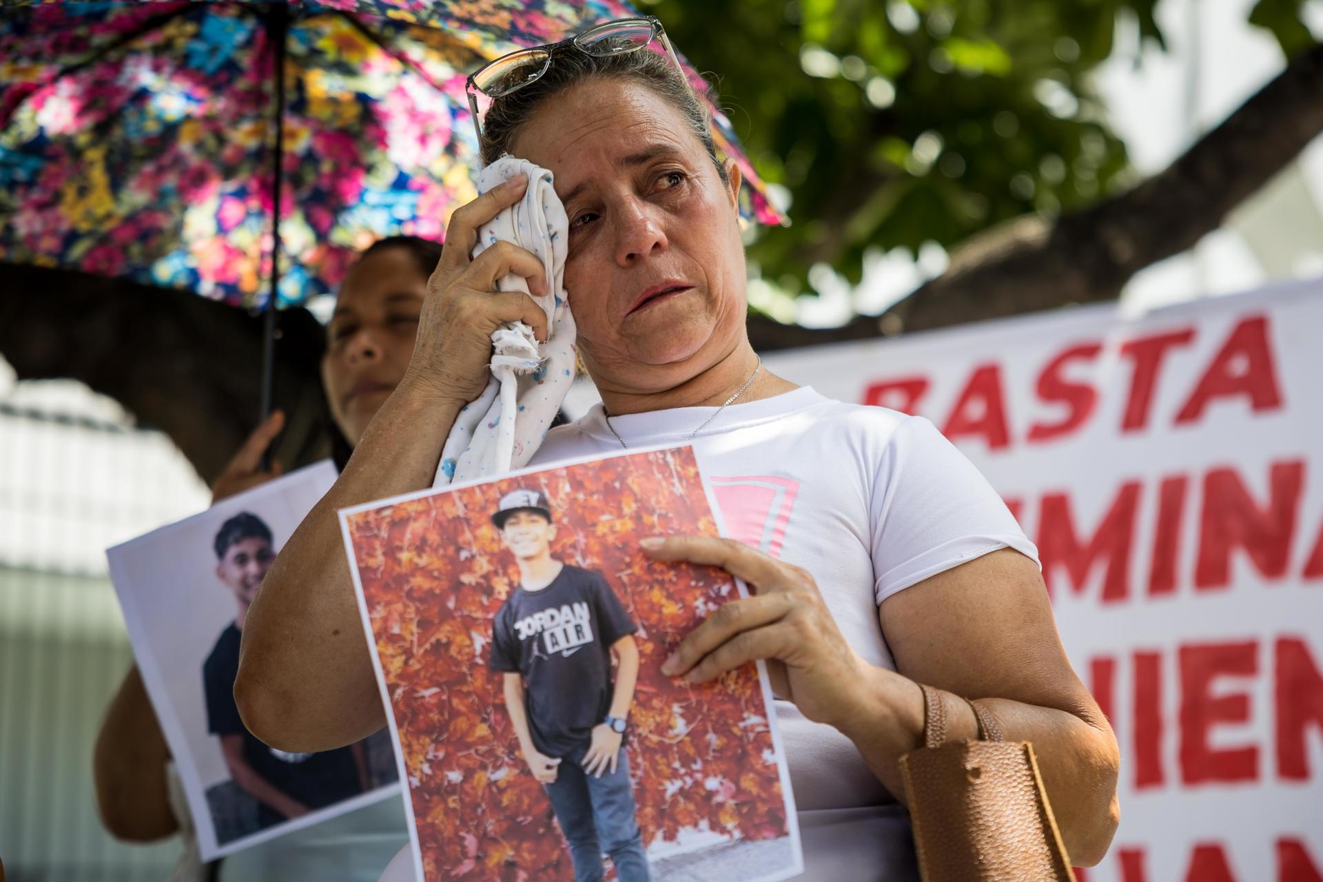 Una mujer llora mientras sostiene una fotografía durante una manifestación y recolección de insumos para familiares "presos políticos" en Caracas (Venezuela). EFE/ Miguel Gutiérrez