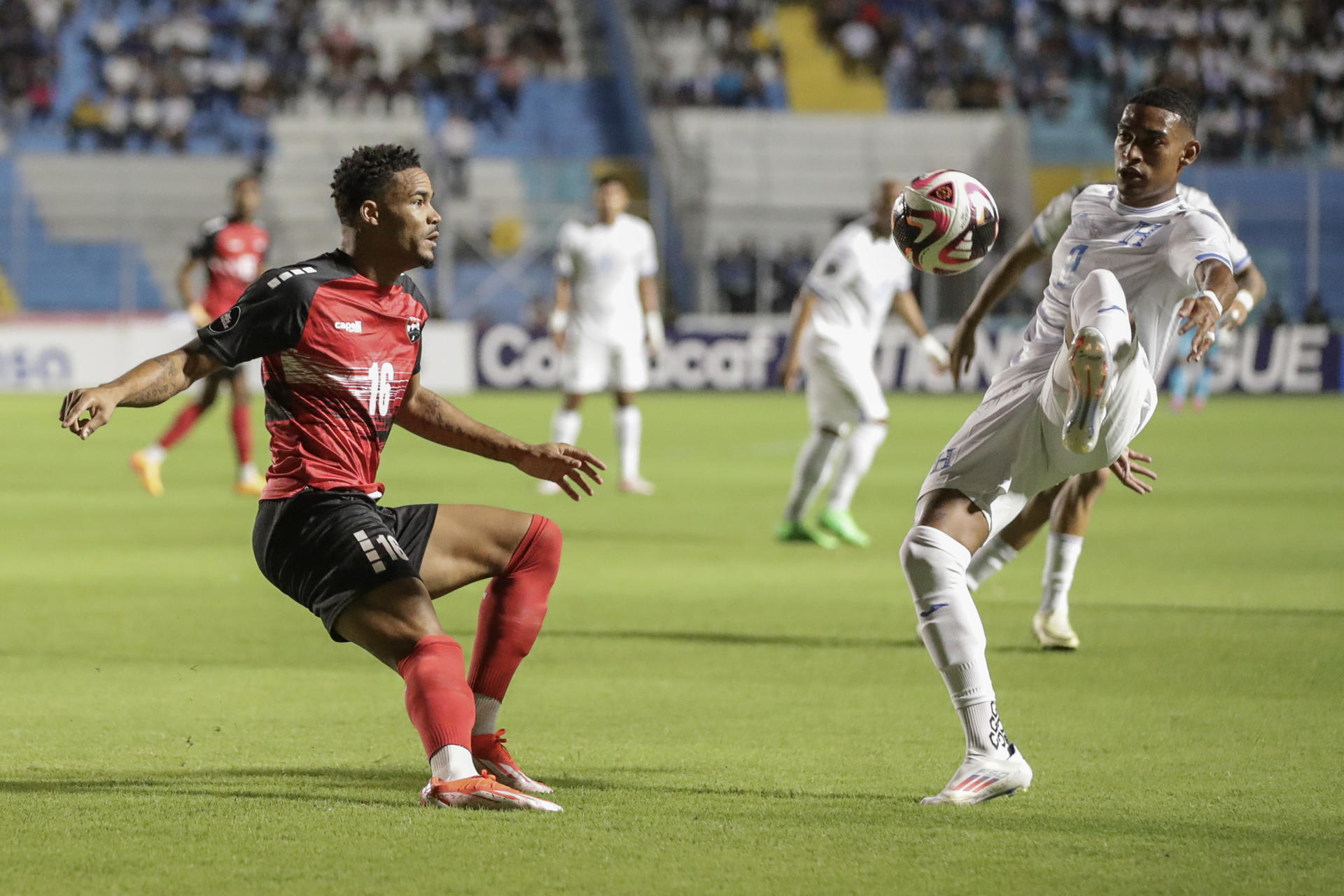 El hondureño Joseph Rosales (d) disputa un balón con el trinitense Alvin Jones este viernes en partido de la primera jornada de la Liga de Naciones de la Concacaf jugado en el estadio Nacional 'Chelato Ucles' en Tegucigalpa. EFE/ Gustavo Amador