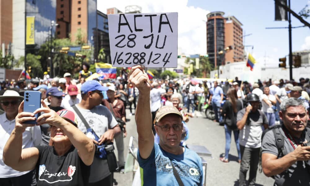 Fotografía de archivo de un seguidor de la líder opositora venezolana María Corina Machado, que sostiene un cartel en una manifestación en Caracas. EFE/ Ronald Peña