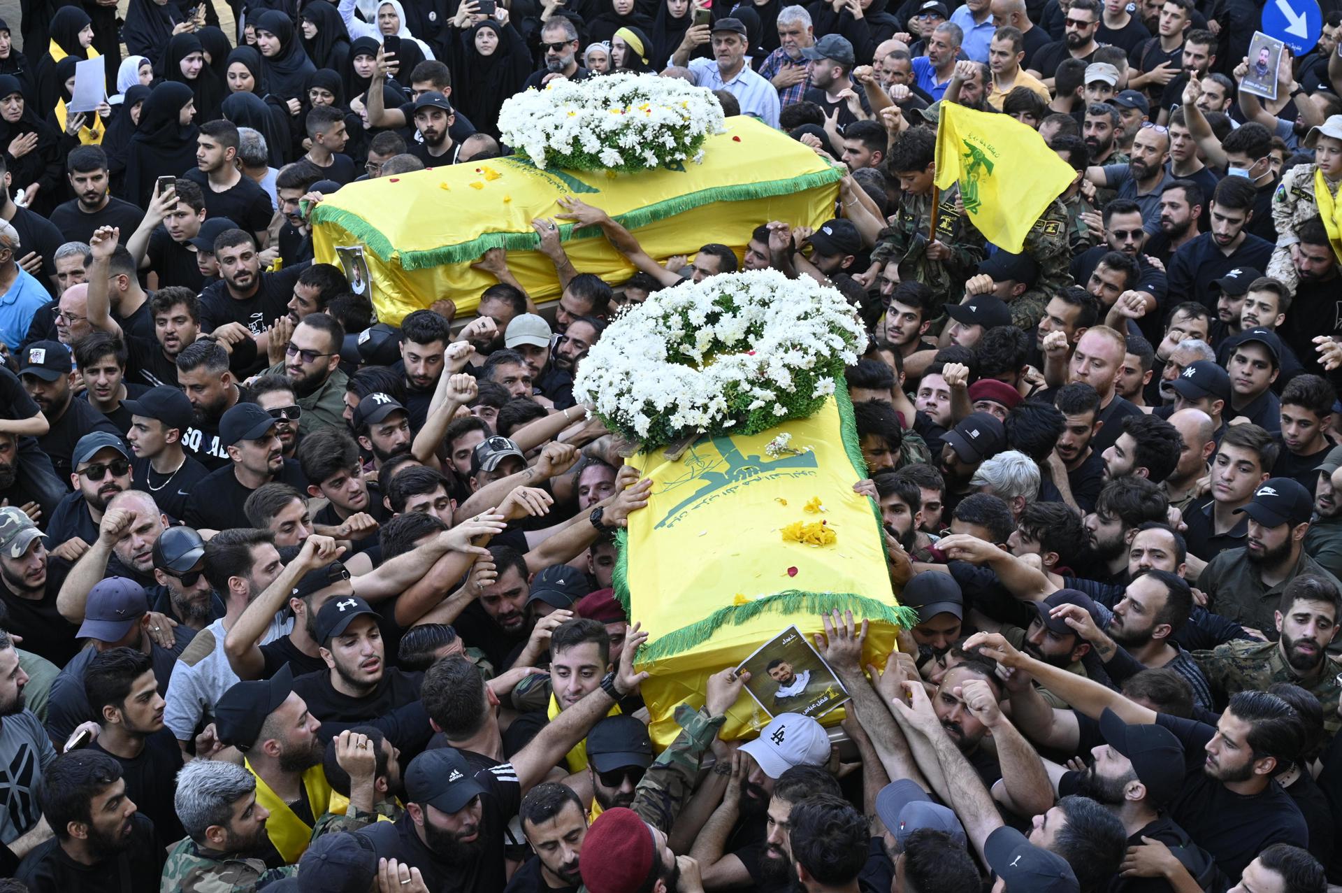 Los dolientes llevan los ataúdes de dos personas que murieron en explosiones de dispositivos de comunicación, durante la procesión fúnebre en Beirut, Líbano, el 19 de septiembre de 2024. El ministro de Salud del Líbano, Firas Abiad, dijo el 19 de septiembre que al menos 37 personas murieron y más de 2.900 resultaron heridas después de que múltiples dispositivos de comunicación inalámbrica fueran detonados el 17 y 18 de septiembre. Hezbolá declaró en un comunicado que Israel estaba detrás del ataque y que habrá consecuencias. (Líbano, Hizbulá/Hezbolá) EFE/EPA/WAEL HAMZEH