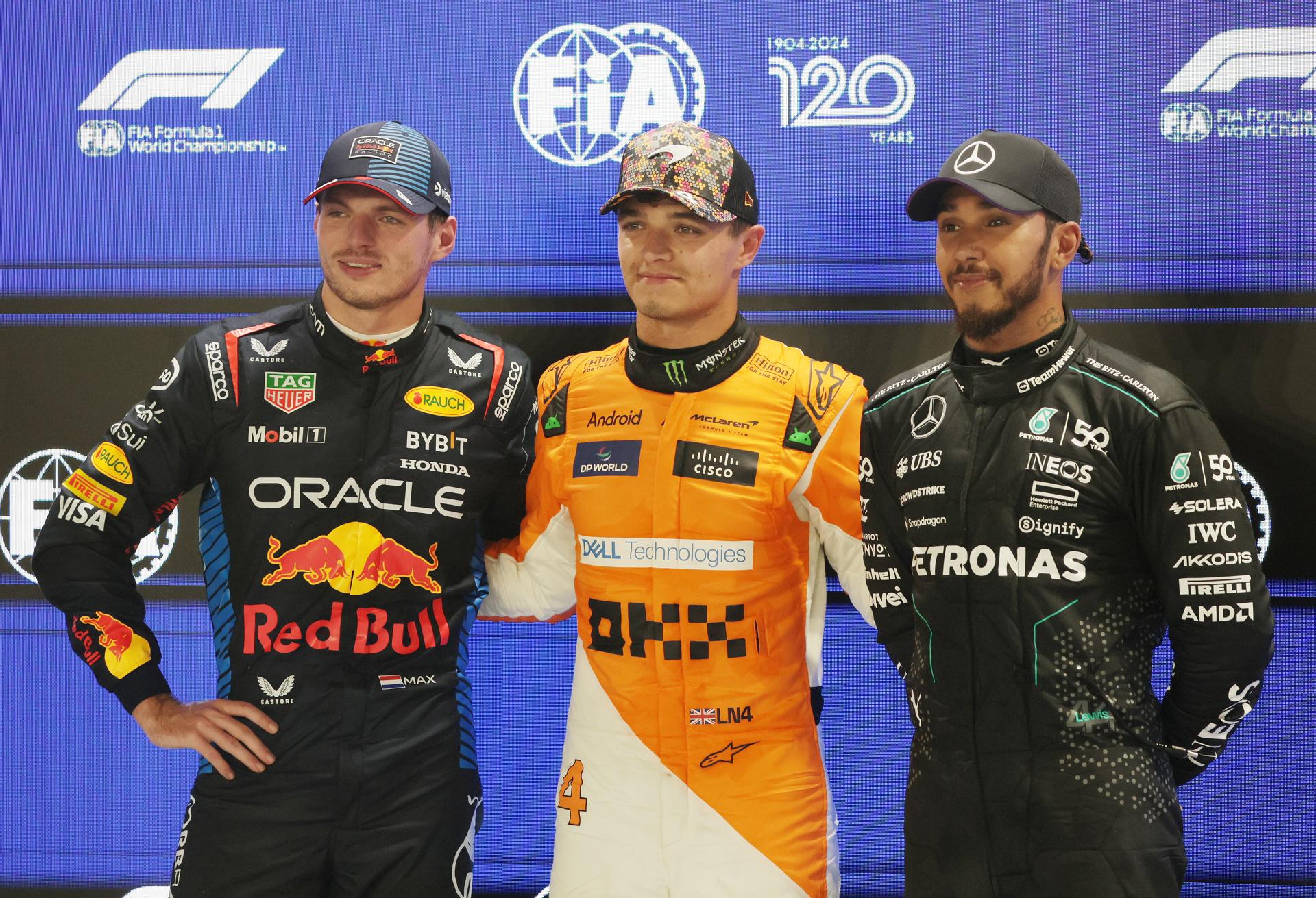 (I-D) El piloto neerlandés Max Verstappen, de la escudería Red Bull Racing, el británico Lando Norris, de McLaren F1 Team, y el también británico Lewis Hamilton, de la escudería Mercedes-AMG Petrona, en el podio en el circuito urbano de Marina Bay en Singapur. EFE/EPA/TOM WHITE