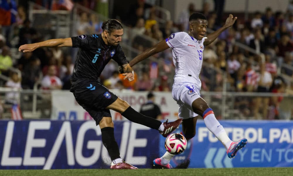 Zarek Valentin (i) de Puerto Rico disputa el balón con Jean Denley de Haití en un partido de la Liga de Naciones de la Concacaf, en el estadio José Antonio Figueroa en Mayagüez (Puerto Rico). EFE/ Thais Llorca