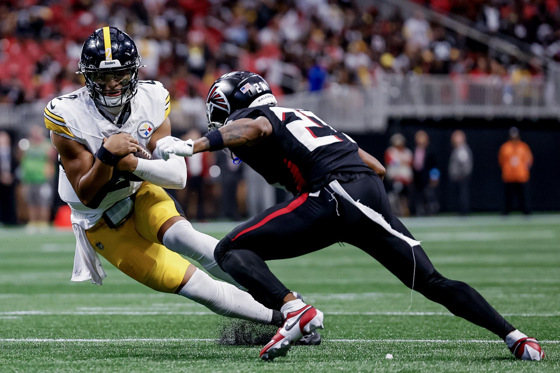 El 'quarterback' de los Steelers, Justin Fields (i), en acción ante Richie Grant, de los Falcons, durante el juego en Atlanta. EFE/EPA/ERIK S. LESSER