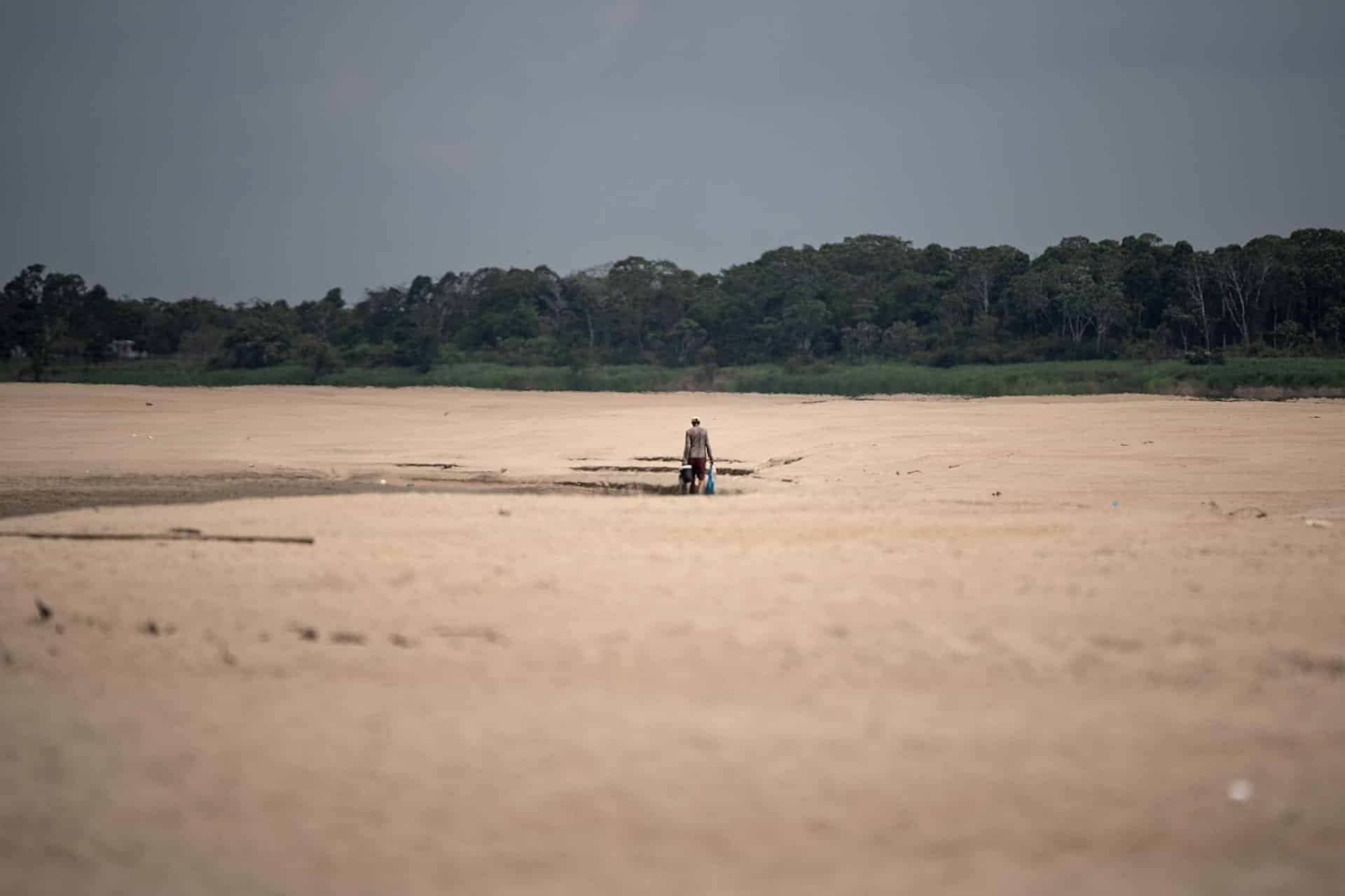 Fotografía del 3 de octubre de 2024 en donde se ve un hombre que camina en la arena a la orilla del río Solimões, en la región de Manacapuru, Amazonas (Brasil). EFE/ Raphael Alves