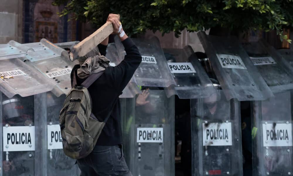 Un encapuchado se enfrenta con la policía durante una protestan este miércoles, por el 56 aniversario de la masacre de Tlatelolco, en la Ciudad de México (México). EFE/José Méndez