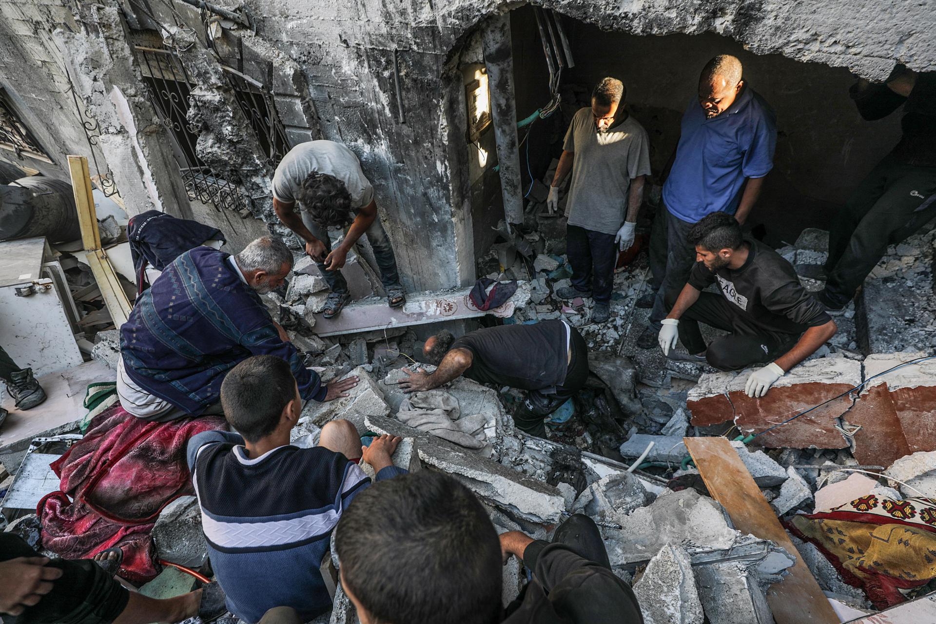 Palestinos buscan cadáveres y supervivientes entre los escombros de una casa destruida tras un ataque aéreo israel en la Franja de Gaza. EFE/Mohammed Saber