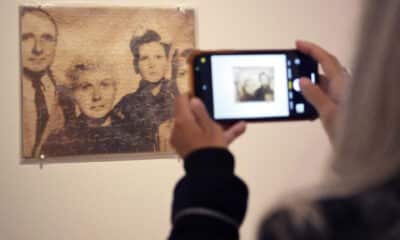 Una persona toma una foto a la obra 'Untitled (Klaus Barbie as a Family)' ('Klaus Barbie en familia'), un rompecabezas con impresión en bolsa de plástico del artista cubano estadounidense Félix González-Torres, durante la presentación de la exhibición 'Felix González-Torres: Always to return' este jueves, en la Galería Nacional de Retratos en el centro de Washington (EE. UU). EFE/Lenin Nolly