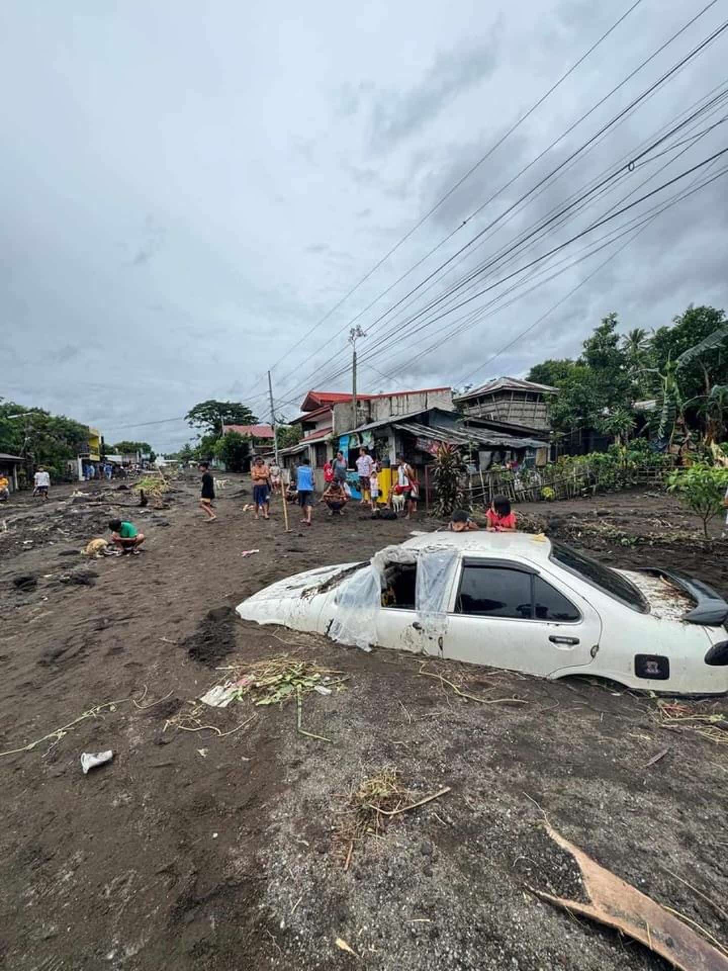 Guinobatan (Philippines), 23/10/2024.- A handout picture made available by the Philippine Red Cross (PRC) shows villagers viewing vehicle buried by volcanic mud that flowed down from Mayon volcano after a heavy rains caused by Typhoon Trami in Guinobatan, Albay province Philippines, 23 October 2024 (issued on 24 October 2024). According to Philippine Civil Defense office, thousands of villagers were forced to evacuate as Typhoon Trami barrels towards the eastern part of the country. (Filipinas) EFE/EPA/Philippine Red Cross HANDOUT HANDOUT EDITORIAL USE ONLY/NO SALES