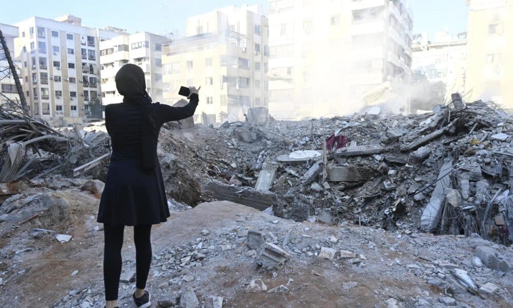 Una mujer toma una foto de un edificio destruido en el barrio de Haret Hreik, en los suburbios del sur de Beirut, tras los ataques militares israelíes sobre Beirut. EFE/ WAEL HAMZEH