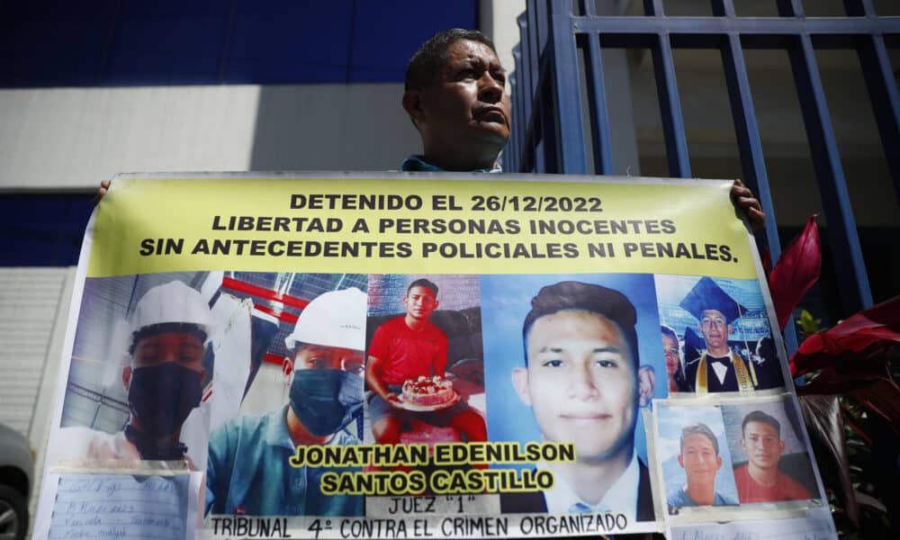 Fotografía de archivo de un familiar de un joven detenido bajo el régimen de excepción en El Salvador, que muestra una pancarta a las afueras de una sede de la Fiscalía General, en Antiguo Cuscatlán (El Salvador). EFE/ Rodrigo Sura