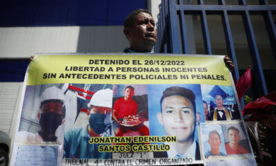 Fotografía de archivo de un familiar de un joven detenido bajo el régimen de excepción en El Salvador, que muestra una pancarta a las afueras de una sede de la Fiscalía General, en Antiguo Cuscatlán (El Salvador). EFE/ Rodrigo Sura