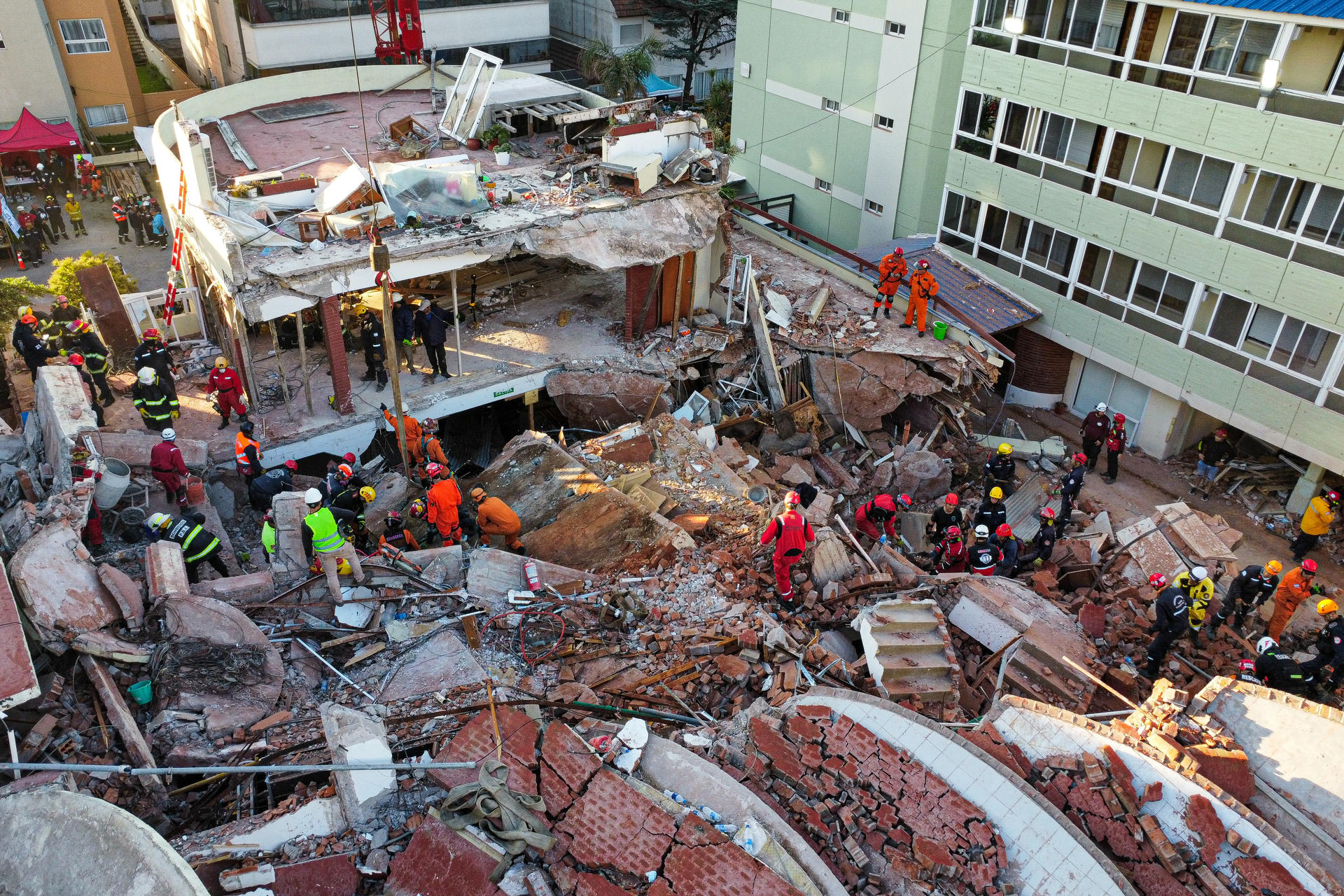 Fotografía aérea que muestra integrantes de los bomberos y grupos de rescate trabajando en la búsqueda de personas entre los escombros del edificio Aparthotel Dubrovnik, en el municipio de Villa Gesell, provincia de Buenos Aires (Argentina). EFE/ STR