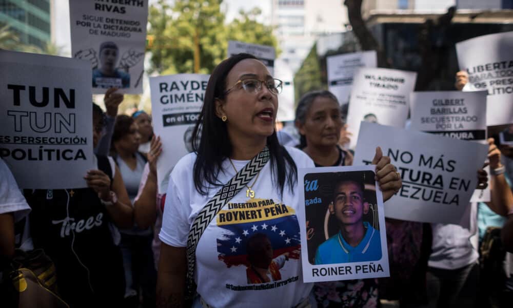 Imagen de archivo de una mujer que sostiene un cartel con la imagen de un detenido durante una manifestación frente a la sede del Ministerio de Servicio Penitenciario, en Caracas. EFE/ Miguel Gutierrez