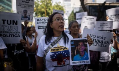 Imagen de archivo de una mujer que sostiene un cartel con la imagen de un detenido durante una manifestación frente a la sede del Ministerio de Servicio Penitenciario, en Caracas. EFE/ Miguel Gutierrez