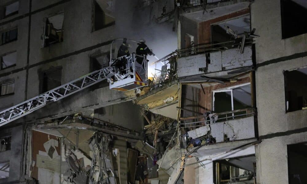 Los equipos de rescate trabajan en el lugar de un ataque ruso con bombas aéreas guiadas que destrozó parcialmente un edificio de viviendas de la ciudad de Járkov, a altas horas de la noche. EFE/EPA/SERGEY KOZLOV