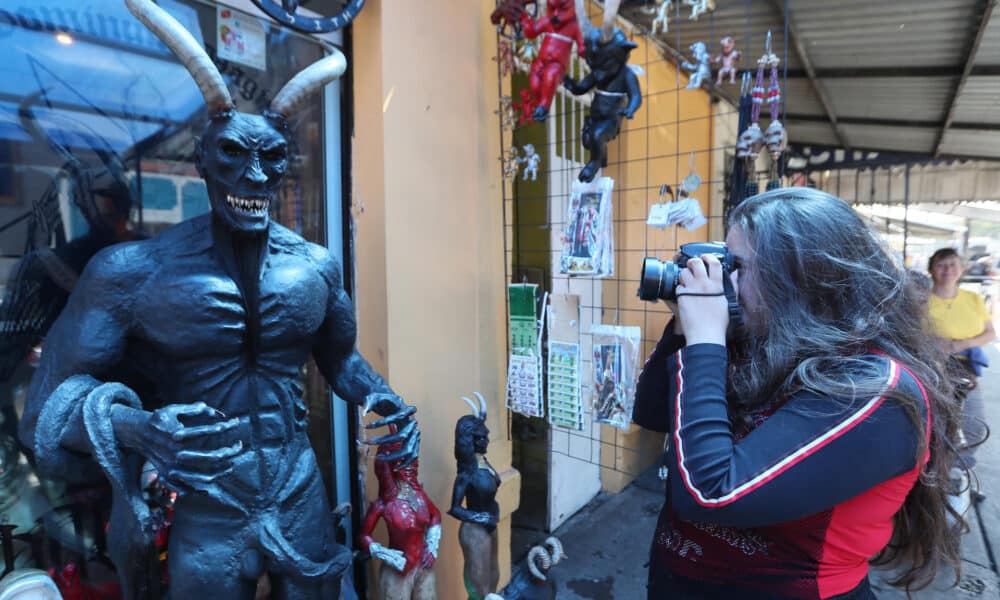 Fotografía del 12 de octubre de 2024 que muestra a una mujer tomando una fotografía en el altar al "Angelito Negro" en el barrio de Tepito, en la Ciudad de México (México). EFE/Mario Guzmán