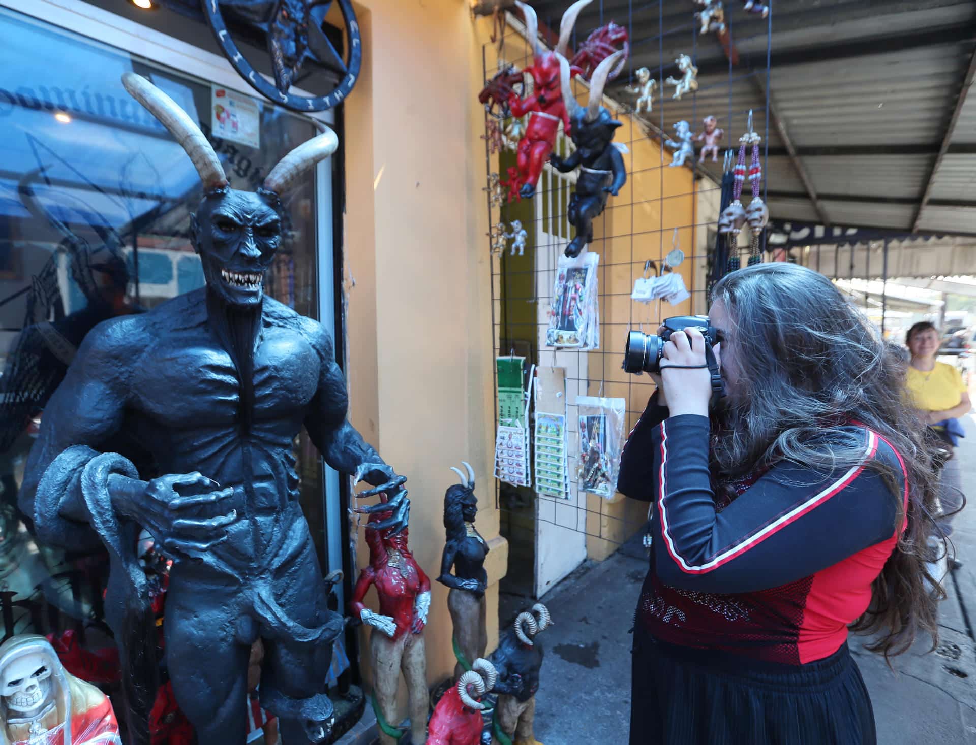 Fotografía del 12 de octubre de 2024 que muestra a una mujer tomando una fotografía en el altar al "Angelito Negro" en el barrio de Tepito, en la Ciudad de México (México). EFE/Mario Guzmán