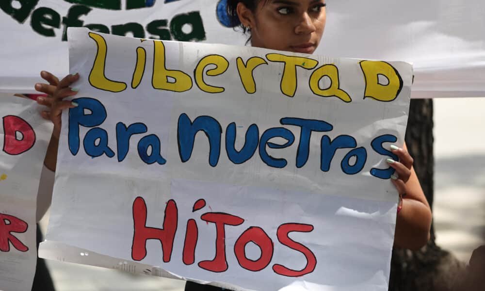 Fotografía de archivo de una mujer sosteniendo un cartel durante una manifestación de familiares de adolescentes detenidos durante las protestas contra los resultados de las elecciones presidenciales en Venezuela. EFE/ Miguel Gutiérrez ARCHIVO