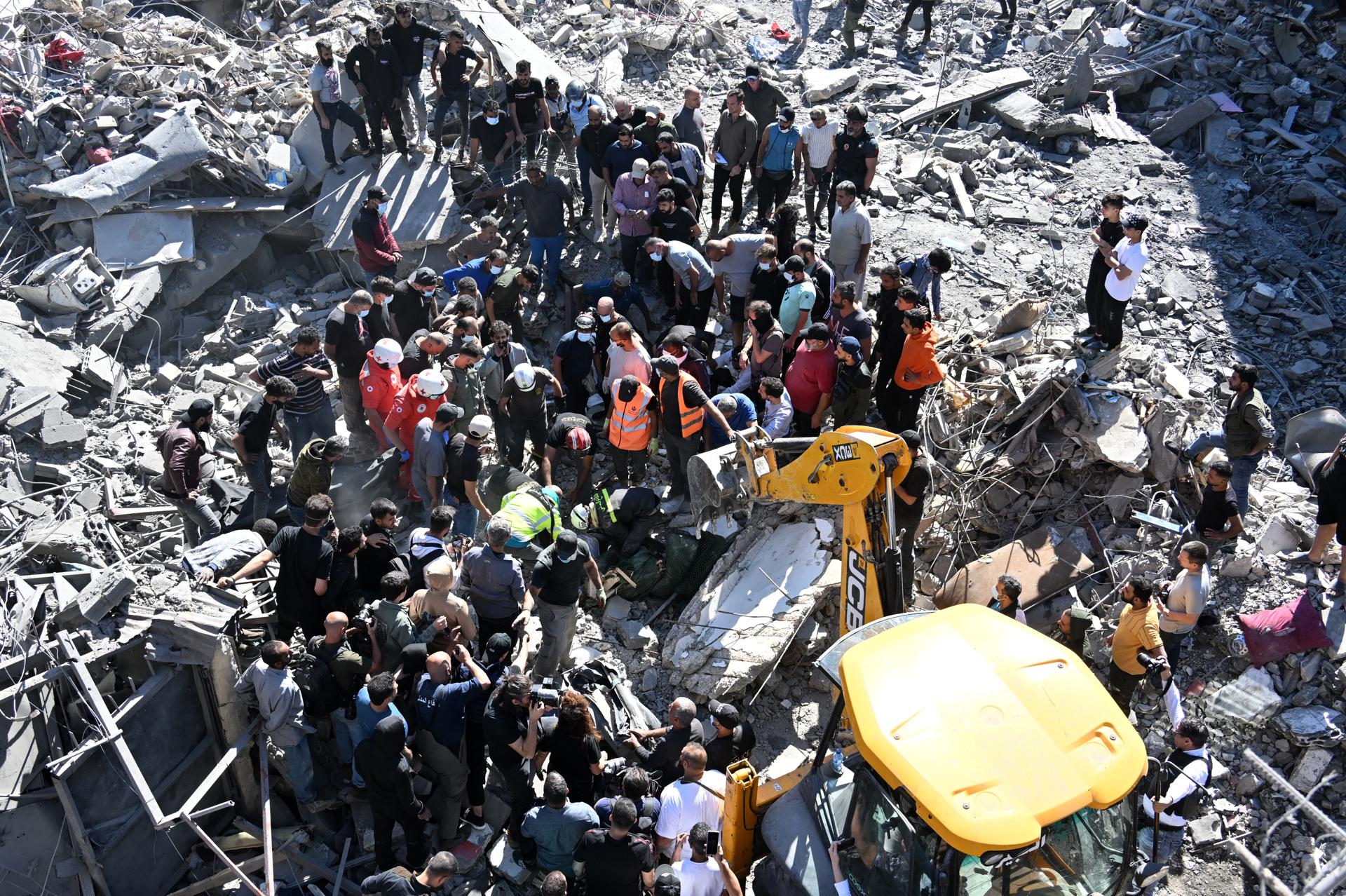 Personas y miembros de los servicios de emergencia trabajan en el lugar de un ataque militar israelí cerca del Hospital Universitario Rafik Hariri (RHUH), en el distrito de Jnah de Beirut, Líbano, el 22 de octubre de 2024. Al menos 13 personas murieron después de un ataque aéreo israelí cerca del hospital público más grande del Líbano, en el sur de Beirut, dijo el Ministerio de Salud libanés. Según este último, más de 2.400 personas han muerto y más de 11.600 han resultado heridas en el Líbano desde el inicio de las recientes escaladas de hostilidades. (Líbano) EFE/EPA/WAEL HAMZEH