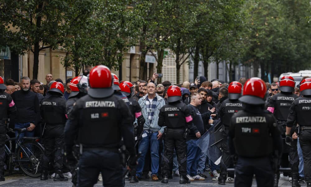 Agentes de la Ertzaintza intentan controlar a aficionados del Anderlecht este jueves en San Sebastián, horas antes del partido de la Liga Europa de fútbol entre la Real Sociedad y el Anderlecht. EFE/Juan Herrero