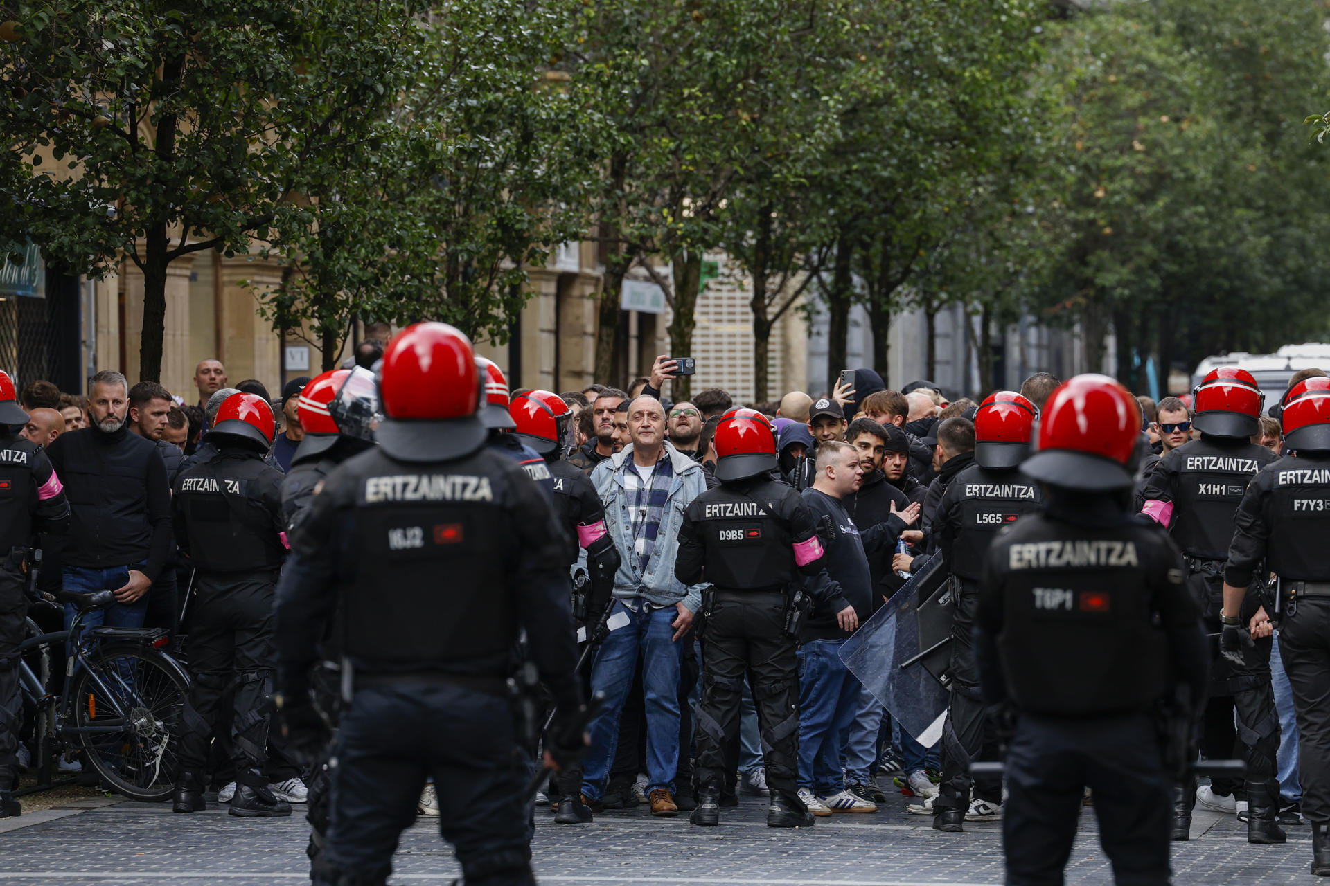 Agentes de la Ertzaintza intentan controlar a aficionados del Anderlecht este jueves en San Sebastián, horas antes del partido de la Liga Europa de fútbol entre la Real Sociedad y el Anderlecht. EFE/Juan Herrero