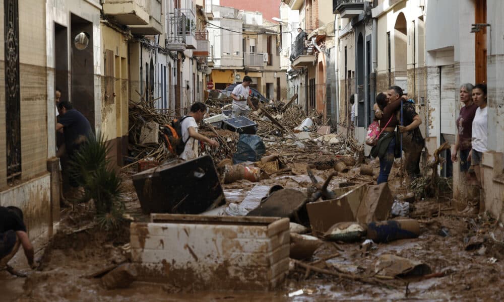 Varias personas trabajan en las labores de limpieza y desescombro en Paiporta, Valencia, este jueves. EFE/ Biel Aliño