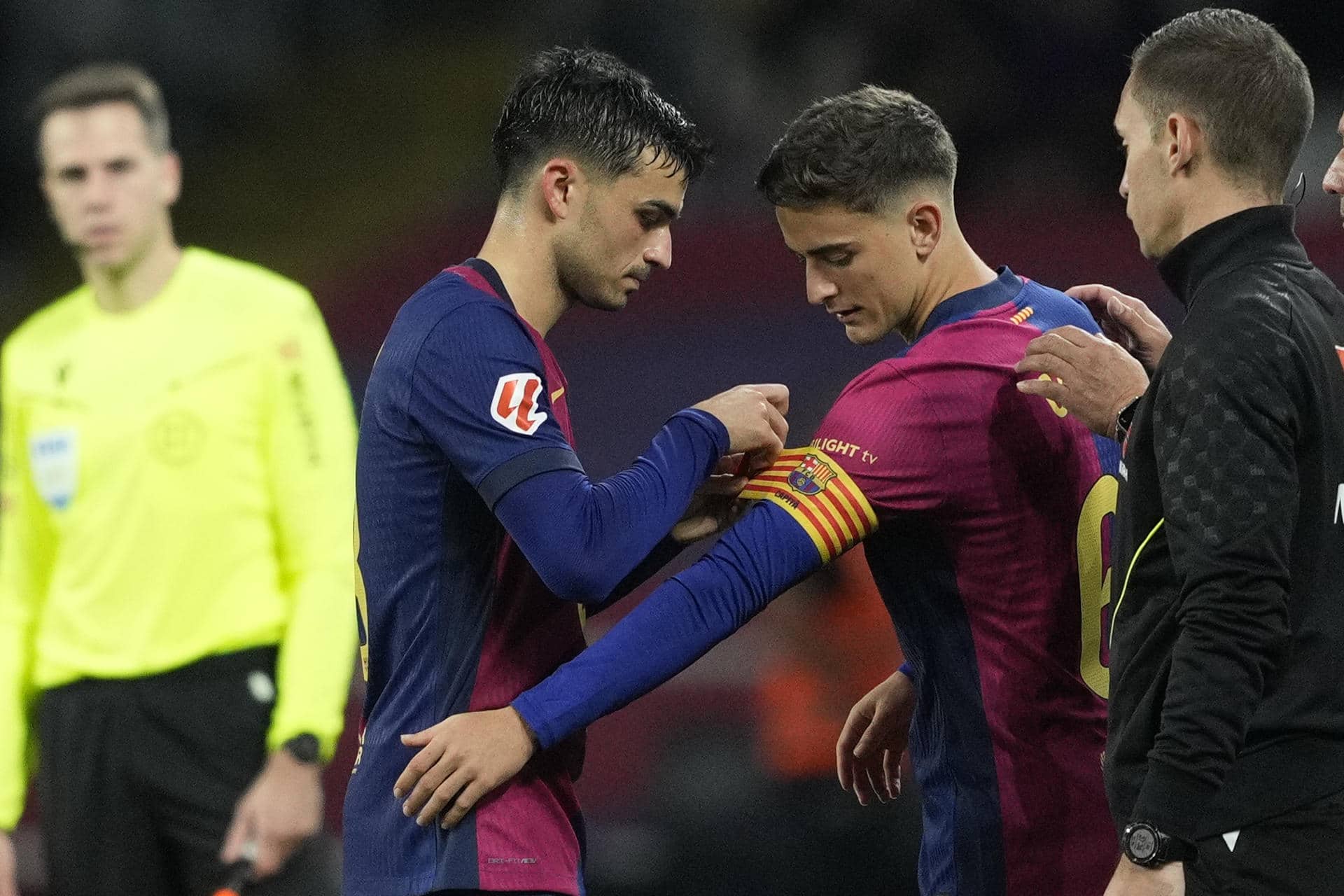 El centrocampista del Barcelona Pedri (i) pone el brazalete de capitán a Gavi al incorporarse al terreno de juego, durante el partido de LaLiga que FC Barcelona y Sevilla FC disputan este domingo en el estadio Lluis Companys. EFE/Alejandro García