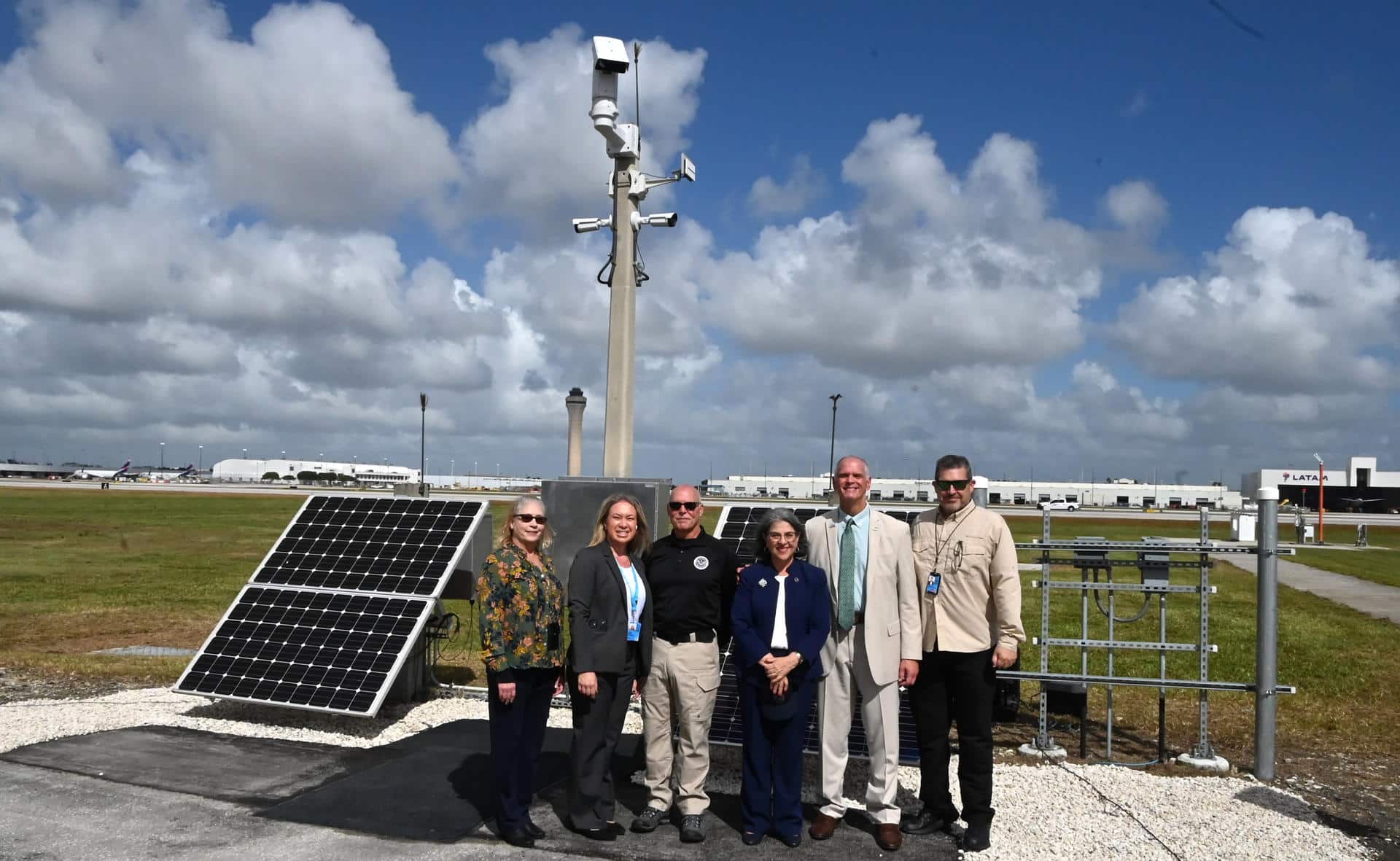 Fotografía cedida por el Aeropuerto Internacional de Miami (MIA) donde aparecen (de izquierda a derecha) la gerente de seguridad del aeropuerto, Susan Feeney; la gerente de construcción, Leslie Livesay; el director de Capacidades Multimodales y de Área Pública (MPAC) de la Administración de Seguridad del Transporte (TSA), Jim Bamberger; la alcaldesa del condado Miami-Dade, Daniella Levine Cava; el director y presidente ejecutivo del aeropuerto, Ralph Cutié, y el director adjunto de seguridad pública y protección, Mark Hatfield, mientras posan cerca de una cámara con Sistema de Detección de Intrusiones Perimetrales (PIDS) en el aeropuerto en Miami, Florida (EE.UU). EFE/MIA