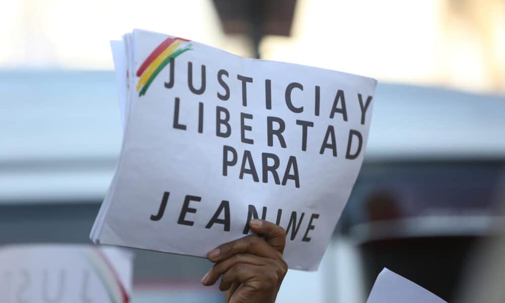 Un simpatizante de la expresidenta interina de Bolivia, Jeanine Áñez (2019-2020), sostiene un cartel afuera del juzgado donde se desarrolla su juicio este jueves, en La Paz (Bolivia). EFE/ Luis Gandarillas