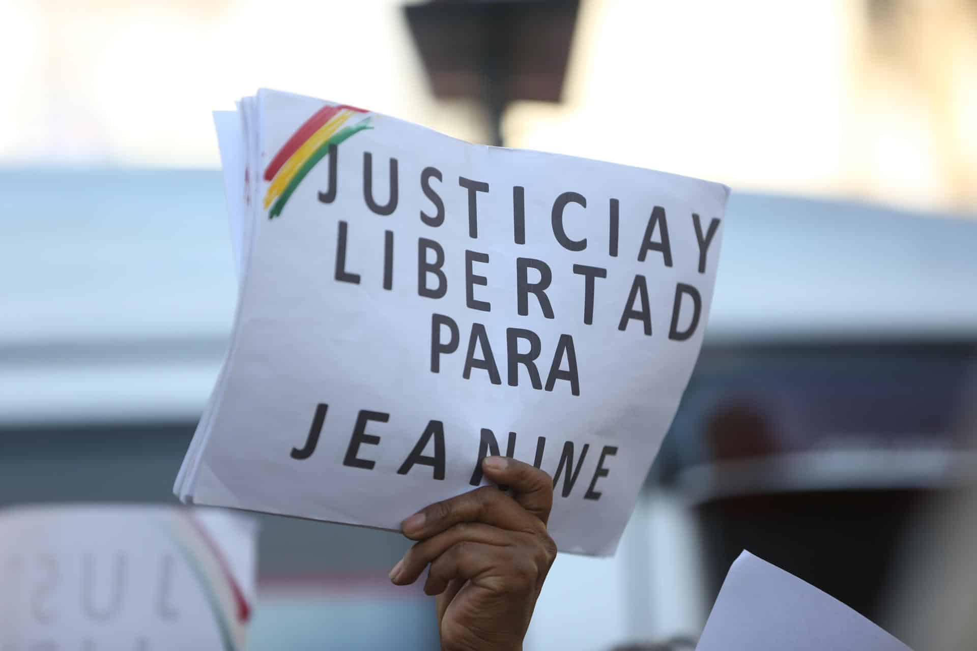 Un simpatizante de la expresidenta interina de Bolivia, Jeanine Áñez (2019-2020), sostiene un cartel afuera del juzgado donde se desarrolla su juicio este jueves, en La Paz (Bolivia). EFE/ Luis Gandarillas