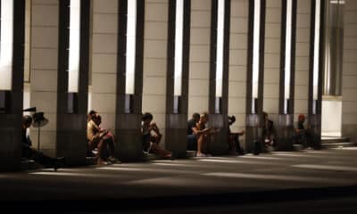 Personas revisan sus teléfonos celulares en el portal de un hotel con electricidad por las plantas eléctricas en La Habana (Cuba). EFE/ Ernesto Mastrascusa