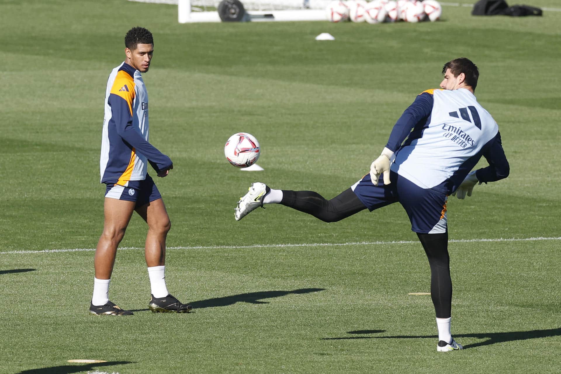 Thibaut Courtois (d) despeja el balón en presencia del centrocampista inglés Jude Bellingham. El portero belga ha sido incluido en la convocatoria para el partido ante el Celta de Vigo. EFE/Juan Carlos Hidalgo