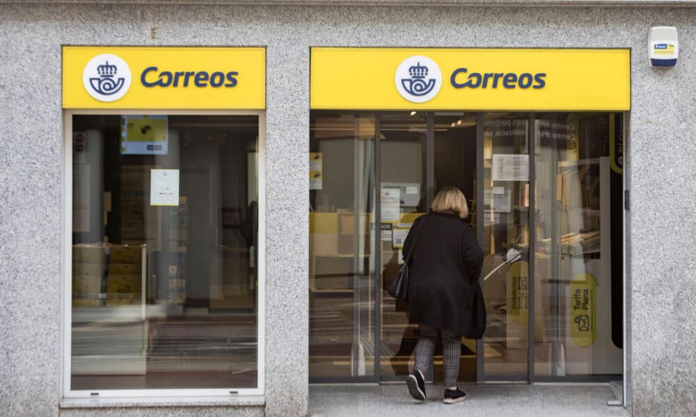 Una mujer entra en una oficina de Correos. EFE/ARCHIVO/ David Arquimbau Sintes