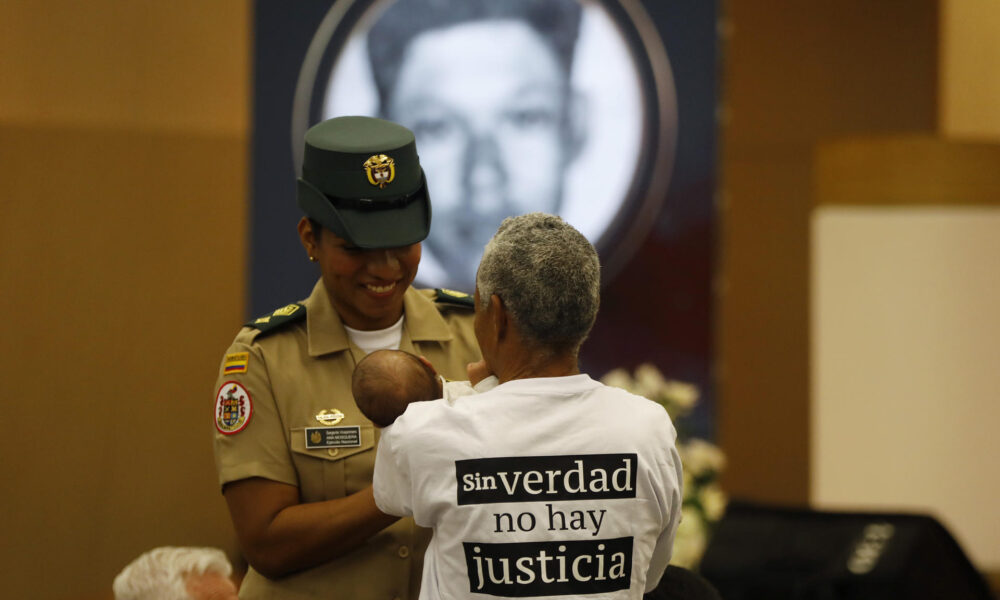 Foto de archivo de una familiar de víctimas de 'falsos positivos' que le muestra un bebé a una militar durante un acto de excusas públicas por parte del Estado colombiano. EFE/Luis Eduardo Noriega Arboleda