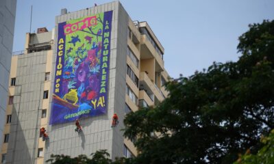 Activistas de Greenpeace despliegan un cartel sobre un edificio este viernes, en la ciudad de Cali (Colombia). EFE/ Ernesto Guzmán