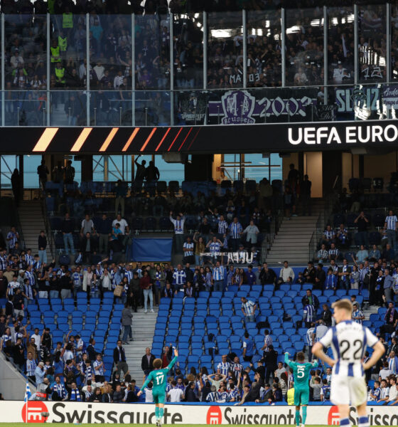 Los jugadores del Anderlecht Theo Leoni (I) y N'Diaye Moussa (C) piden calma a sus aficionados, que lanzan objetos a los seguidores de la Real Sociedad desde la grada superior del estadio Reale Arena de San Sebastián. EFE/Juan Herrero