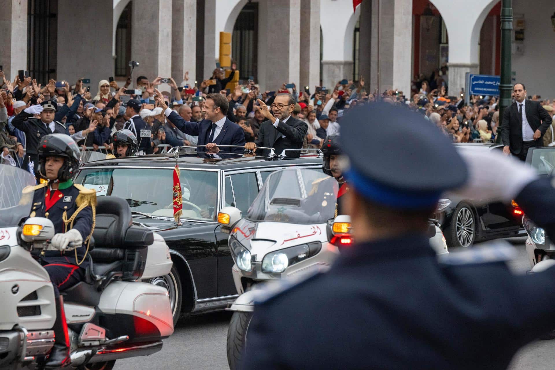 El rey de Marruecos, Mohammed VI (centro-derecha), y el presidente francés, Emmanuel Macron (centro-izquierda), saludan a la multitud mientras viajan en un automóvil abierto por una carretera en Rabat, Marruecos, el 28 de octubre de 2024. El presidente francés, Emmanuel Macron, se encuentra en Rabat para una visita de Estado de tres días por invitación del rey Mohammed VI. La visita pretende marcar una nueva ambición para los próximos 30 años en la relación franco-marroquí, según el Palacio del Elíseo. (Francia, Marruecos) EFE/EPA/JALAL MORCHIDI