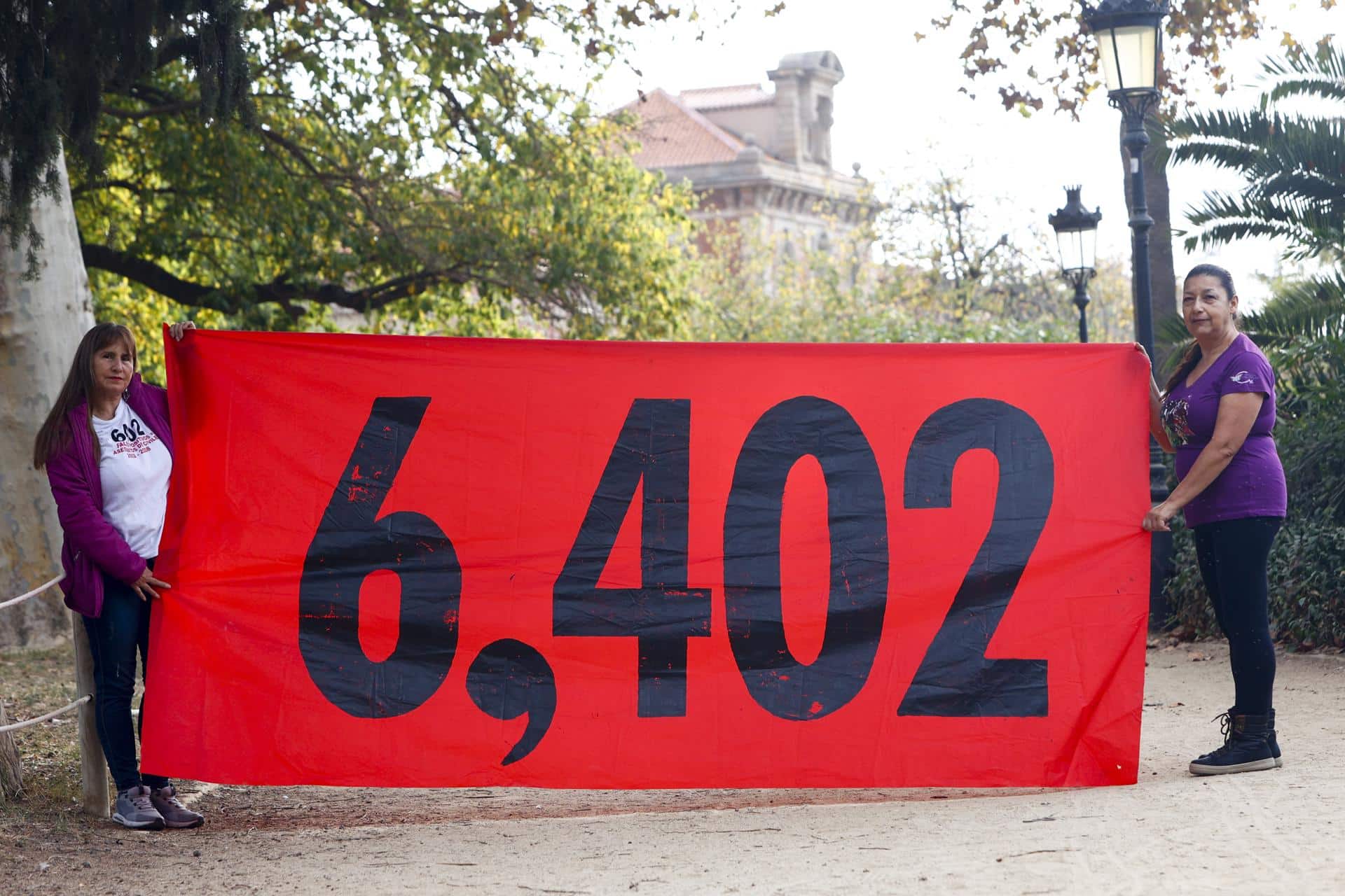 Fotografía de archivo en donde dos mujeres sostienen un cartel con la cifra de 6.402 víctimas de los llamados 'falsos positivos', asesinatos y desapariciones forzadas perpetradas por militares del Ejército colombiano pero que fueron presentadas como bajas en combate durante el periodo de 2002-2008, durante el Gobierno de Álvaro Uribe (2002-2010), a cambio de recompensas o beneficios. EFE/Quique García