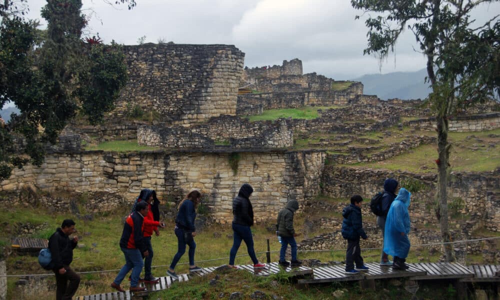 Fotografía dearchivo que muestra a una familia de turistas paseando en mitad de la lluvia frente al templo mayor de la ciudad fortificada de Kuélap, el mayor exponente arquitectónico de la civilización prehispánica Chachapoyas, en la región peruana de Amazonas. EFE/Fernando Gimeno