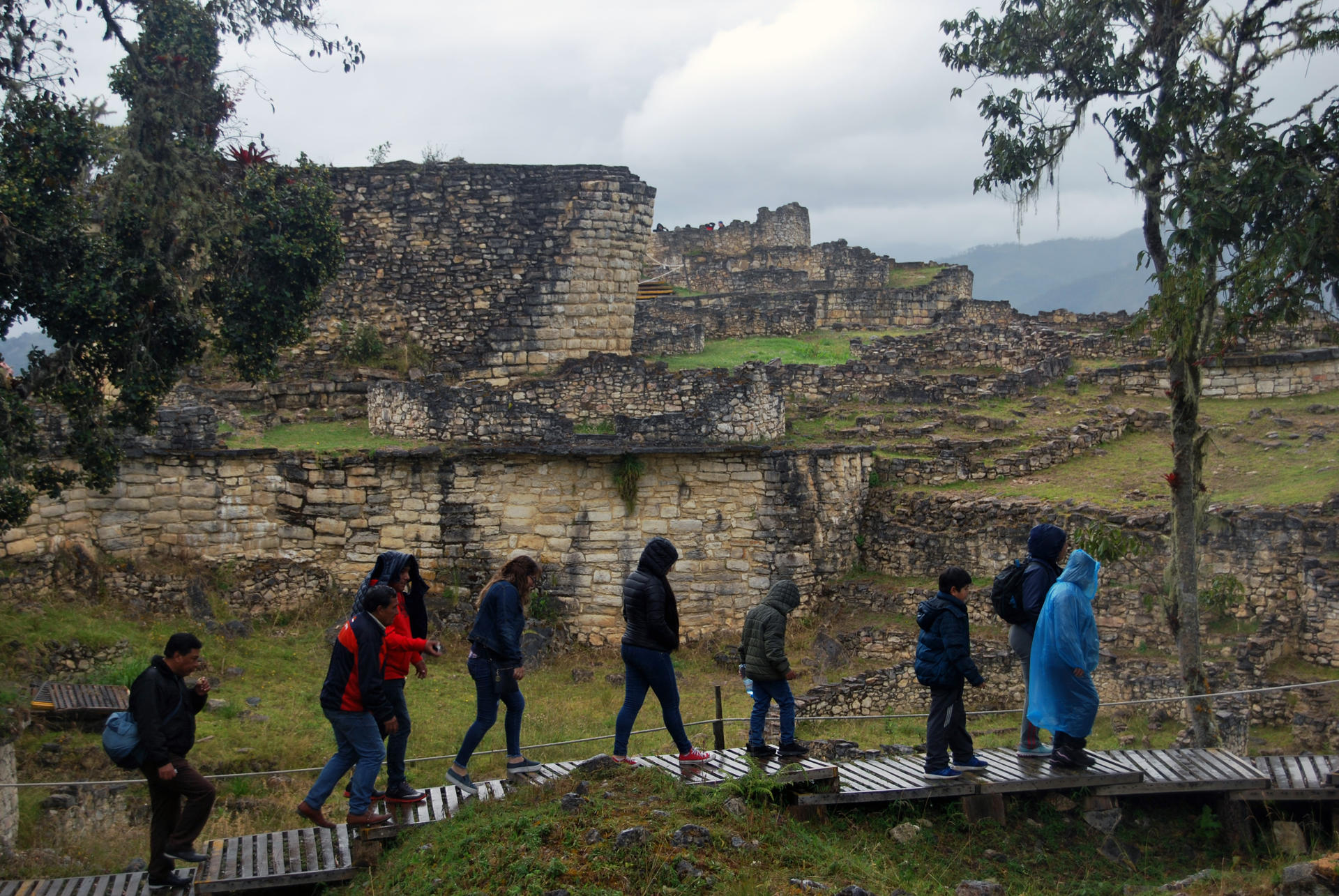 Fotografía dearchivo que muestra a una familia de turistas paseando en mitad de la lluvia frente al templo mayor de la ciudad fortificada de Kuélap, el mayor exponente arquitectónico de la civilización prehispánica Chachapoyas, en la región peruana de Amazonas. EFE/Fernando Gimeno